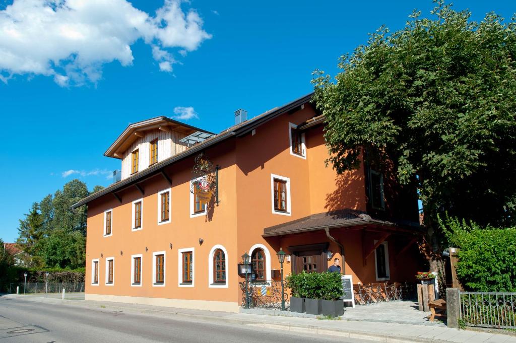 duży pomarańczowy budynek po stronie ulicy w obiekcie Landgasthof zum Erdinger Weissbräu w mieście Rosenheim