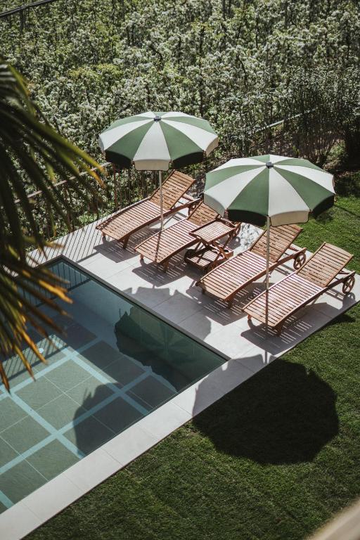 an overhead view of a pool with chairs and umbrellas at Schnitzbichlhof in Lana