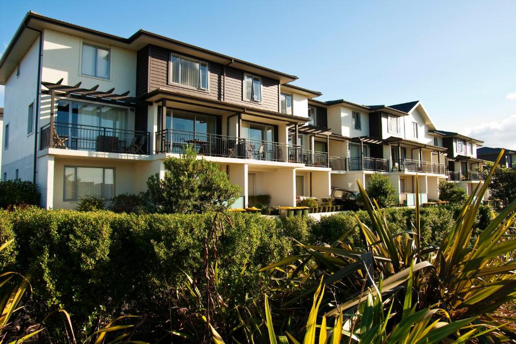 a row of houses with bushes in front of them at Nesuto Newhaven in Auckland