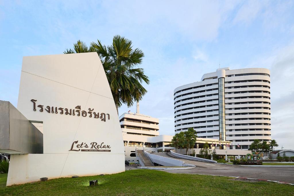 Un edificio alto y blanco con una palmera delante. en Rua Rasada Hotel - The Ideal Venue for Meetings &amp; Events, en Trang