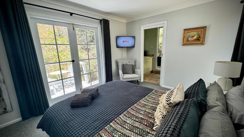 a bedroom with a bed and a couch and a tv at Romantic Getaway - Private Guest Suite - Country setting amongst Orange's best Wineries in Orange