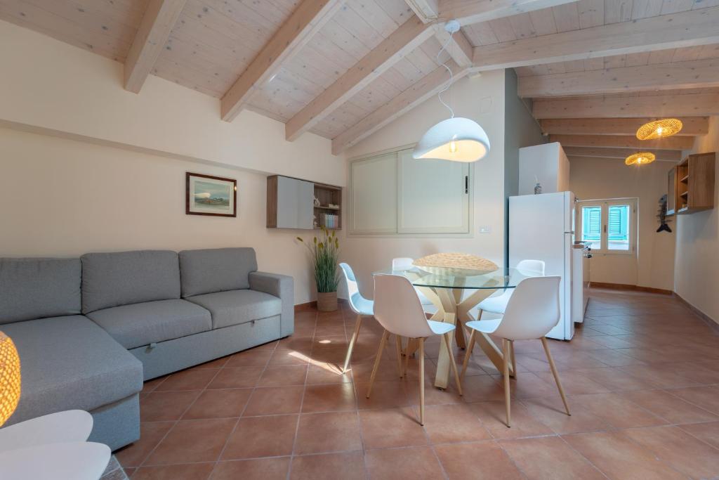 a living room with a couch and a table and chairs at La Nassa in Alghero
