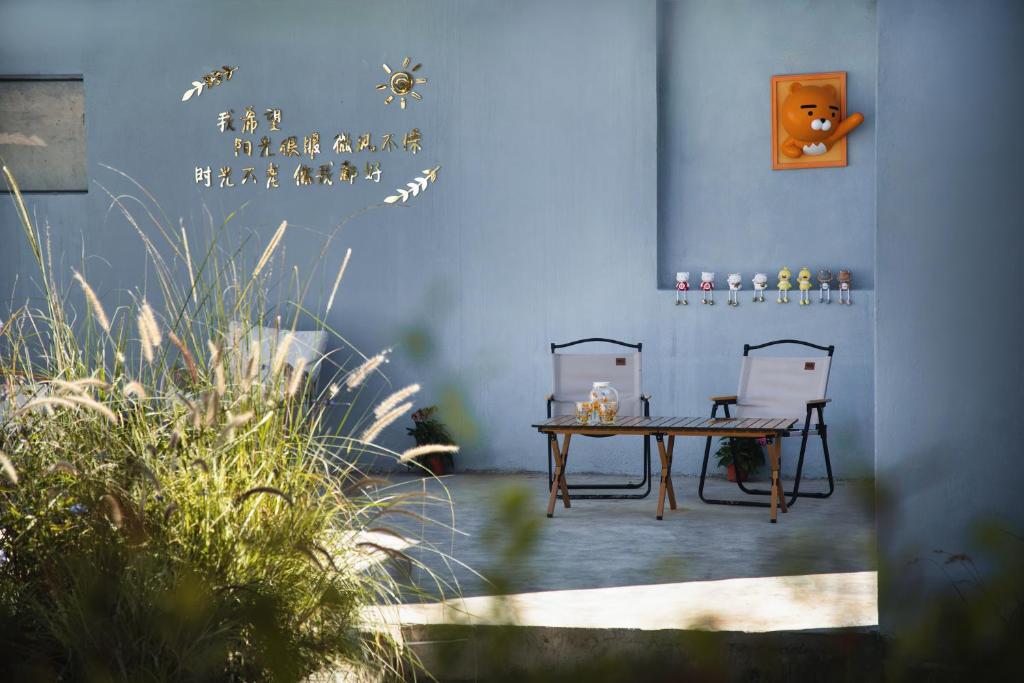 un patio con 2 sillas y una mesa en una habitación en The White Courtyard, en Dali