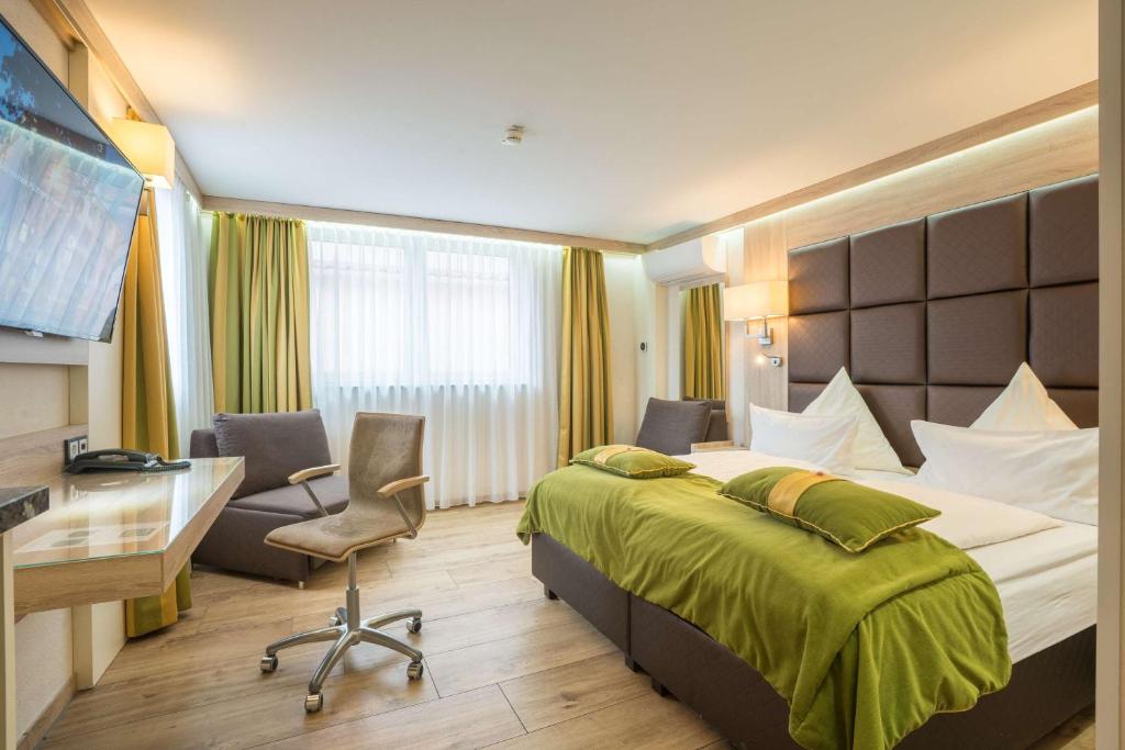 ein Hotelzimmer mit einem Bett und einem Schreibtisch in der Unterkunft Best Western Plus Hotel Füssen in Füssen