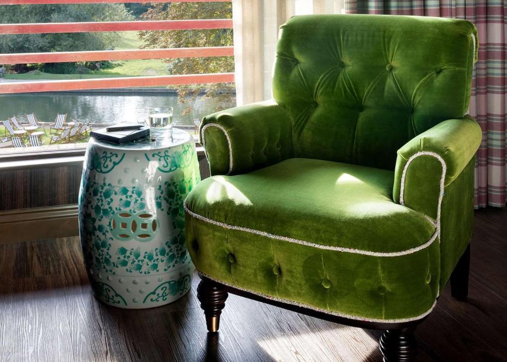 a green chair and a vase in a room at Graduate by Hilton Cambridge in Cambridge