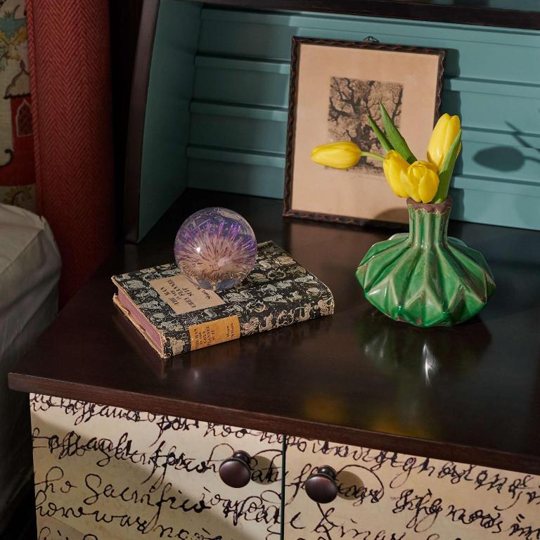 a table with a vase of flowers and books on it at Graduate by Hilton Cambridge in Cambridge