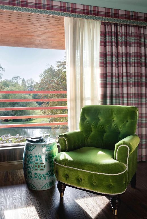 a green chair in a room with a large window at Graduate by Hilton Cambridge in Cambridge