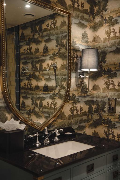 a bathroom with a large mirror and a sink at Graduate by Hilton Cambridge in Cambridge