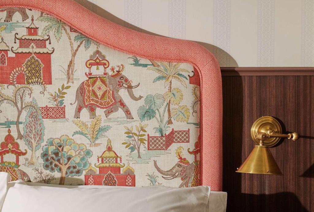 a bedroom with a bed with a tapestry at Graduate by Hilton Cambridge in Cambridge
