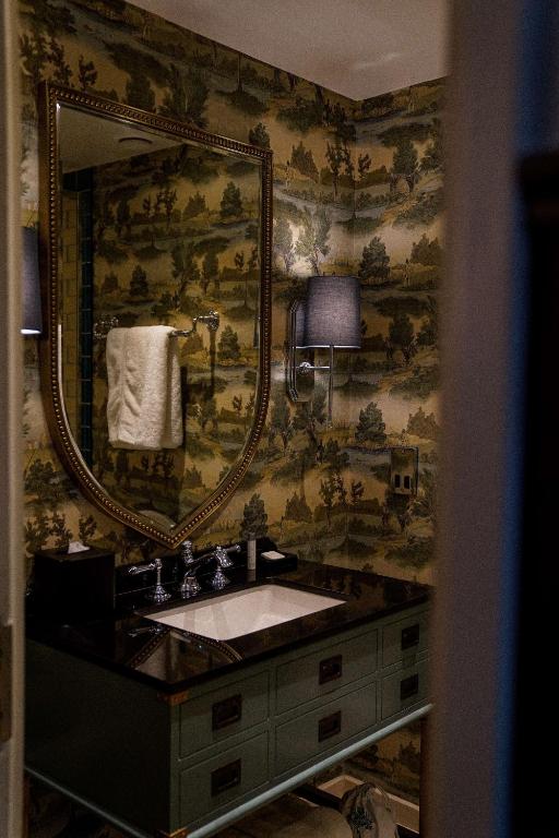 a bathroom with a sink and a large mirror at Graduate by Hilton Cambridge in Cambridge