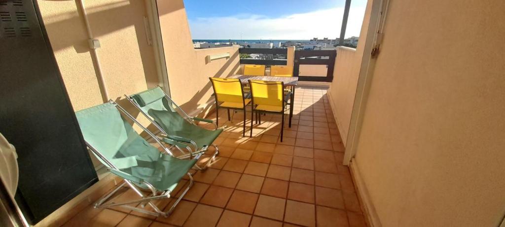 un balcon avec des chaises et une table sur un immeuble dans l'établissement Appartement 357, PORT NATURE colline 3 au village naturiste, au Cap d'Agde