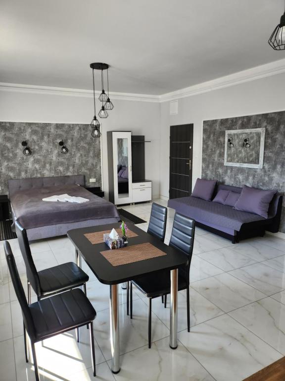 salon z łóżkiem, stołem i krzesłami w obiekcie Apartamenty Polna w Ostrowcu Świętokrzyskim