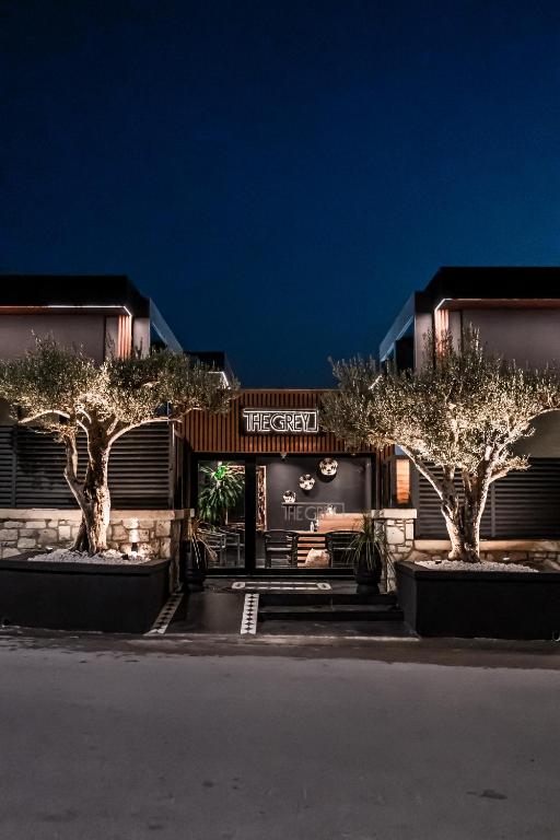 a building with trees in front of it at night at The Grey Alaçatı in Çeşme
