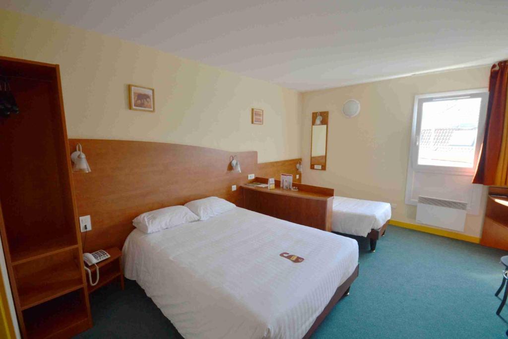 a hotel room with two beds and a window at Adams Hotel in Metz