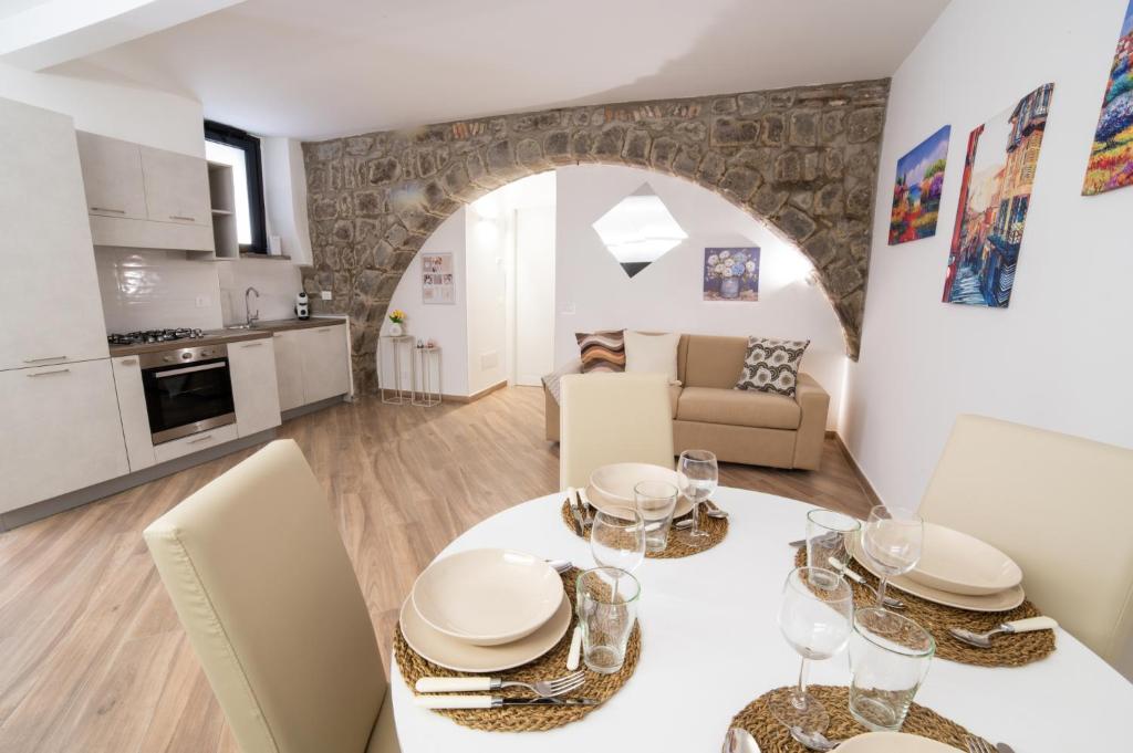 a kitchen and living room with a table and chairs at L'Archetto di Romeo in Montefiascone