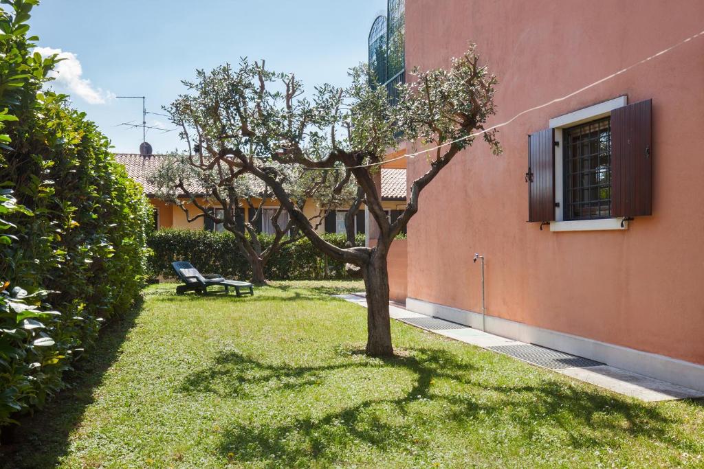 a tree in a yard next to a building at Eli House in Cavaion Veronese