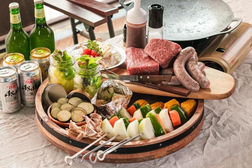 - une table avec des assiettes de nourriture et des bouteilles de vin dans l'établissement The Day Post General Glamping Village Yamanakako - Vacation STAY 25050v, à Yamanakako