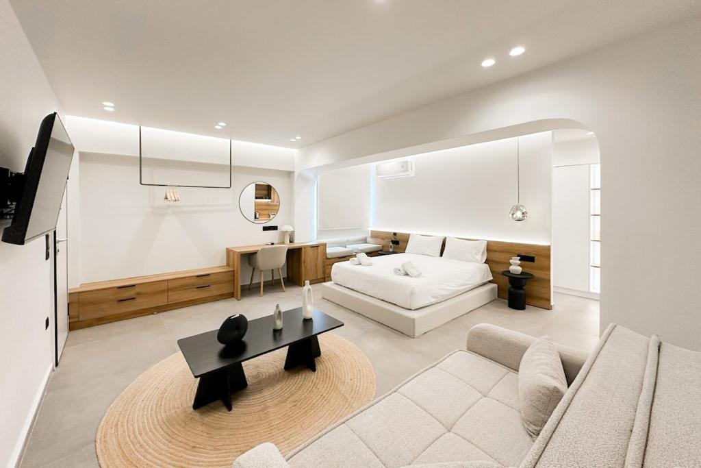 a white living room with a bed and a table at Megaro Luxury Suite 11 in Syntagma in Athens