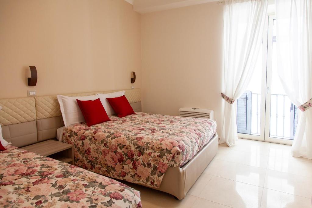 a bedroom with two beds with red pillows at Opera 5 in Naples