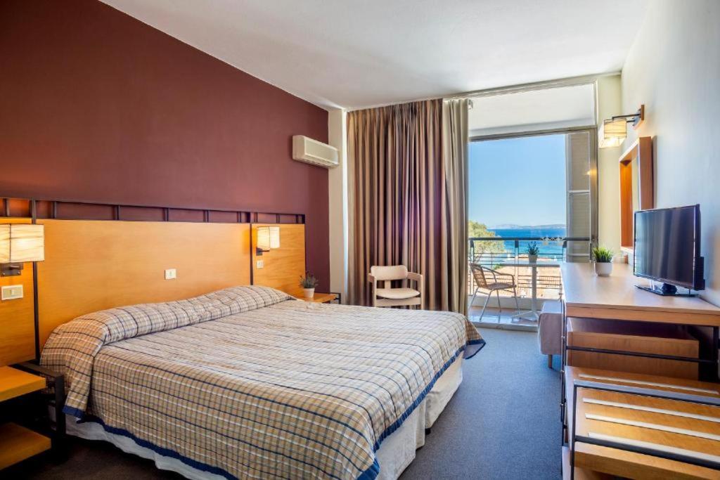 a hotel room with a bed and a television at Spetses Hotel in Spetses