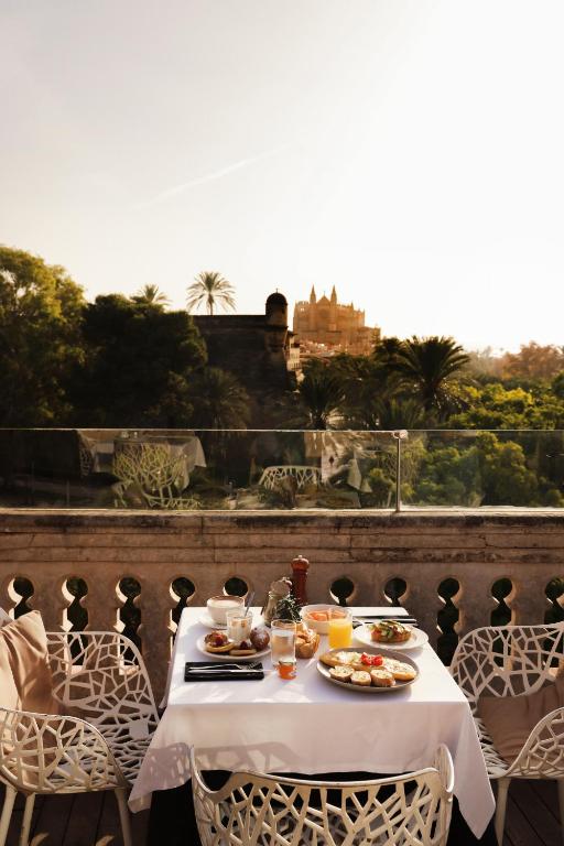 a table with plates of food on top of a balcony at Hotel Hostal Cuba in Palma de Mallorca