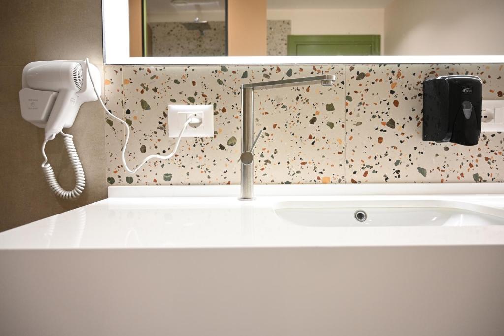 a bathroom with a sink and a phone on the wall at Top view hostel in Durrës
