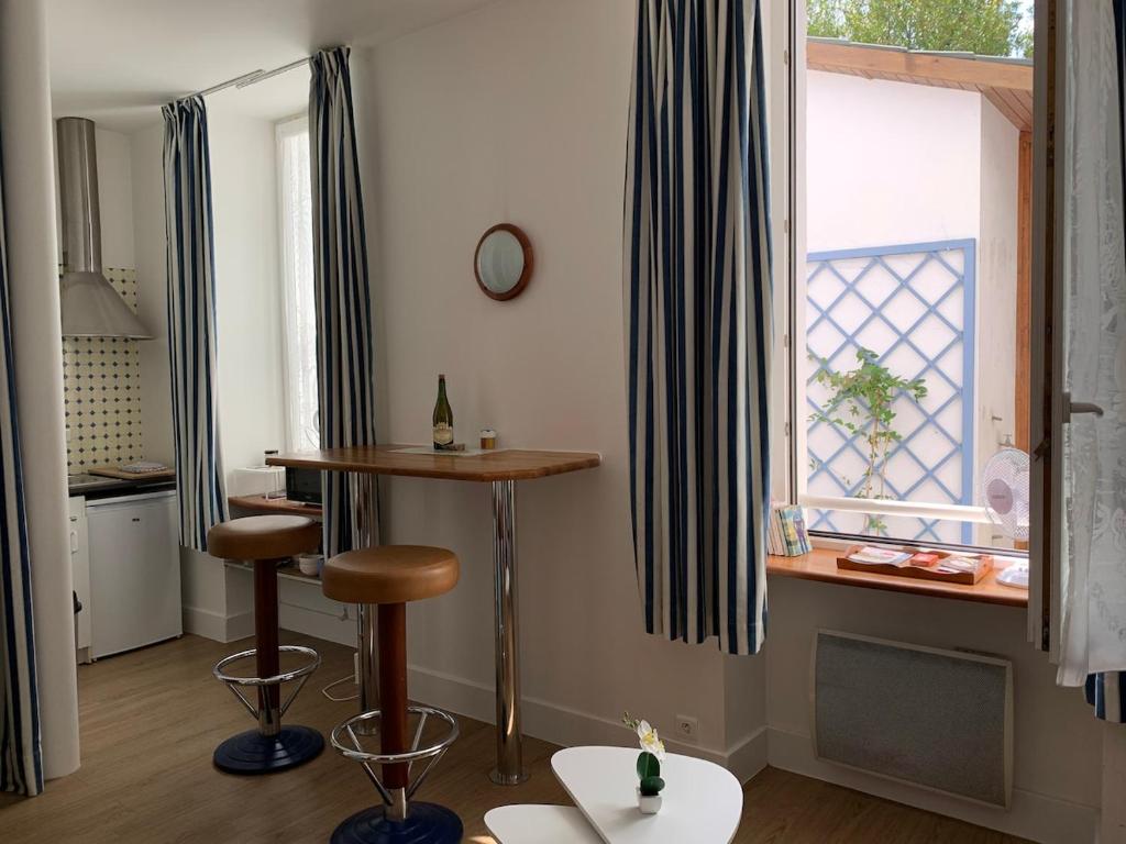 une cuisine avec un tabouret de bar et une fenêtre dans l'établissement Studio idéal pour professionnels ou vacanciers, à Saint-Nazaire