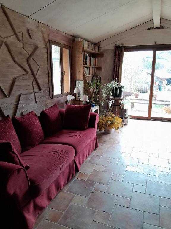 - un salon avec un canapé rouge dans l'établissement Maison isolée tout équipée, à La Piarre