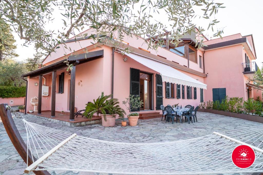 une maison avec un hamac en face de celle-ci dans l'établissement Casa Rosa, à La Spezia