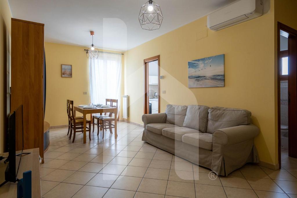 a living room with a couch and a table at Homiday - Palazzo Passerini in Pineto