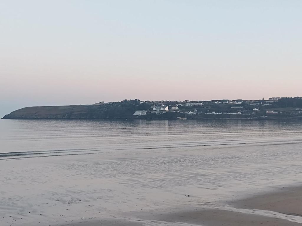 a view of a beach with a town in the distance at Seaside chalet in Ardmore with breathtaking views in Ardmore