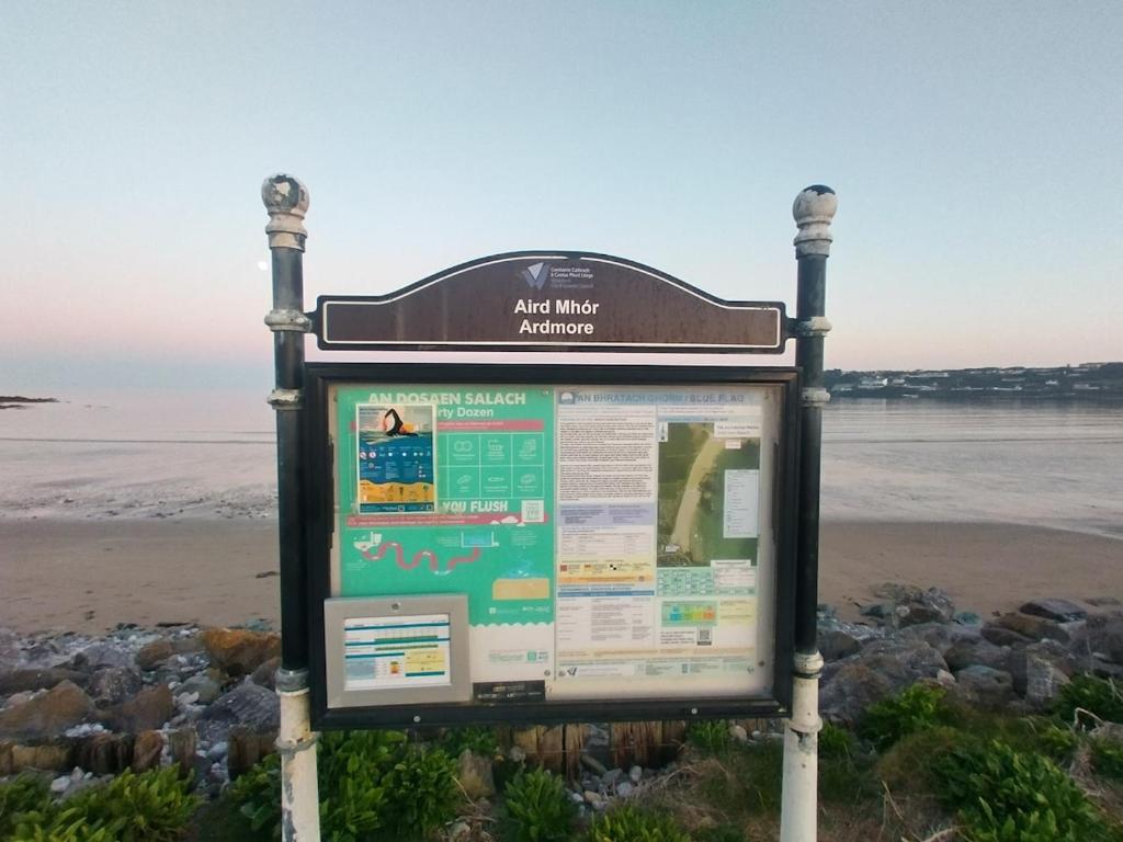 a sign on a beach with the ocean in the background at Seaside chalet in Ardmore with breathtaking views in Ardmore
