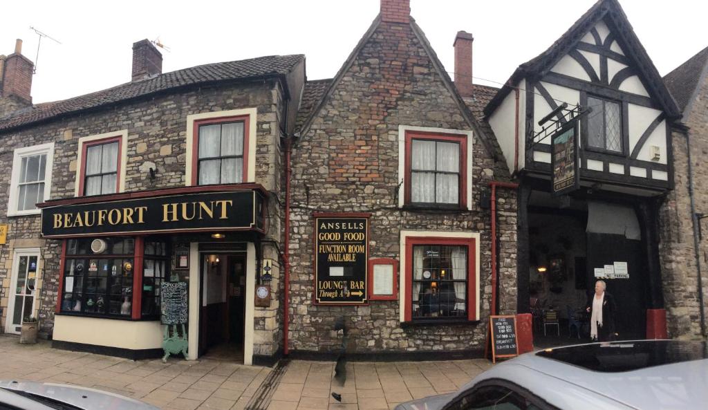 an old brick building with a sign for a restaurant at The Beaufort Hunt in Chipping Sodbury
