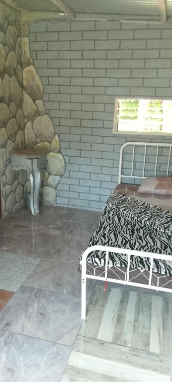 a bed in a room with a stone wall at Panorama in Capalasanan
