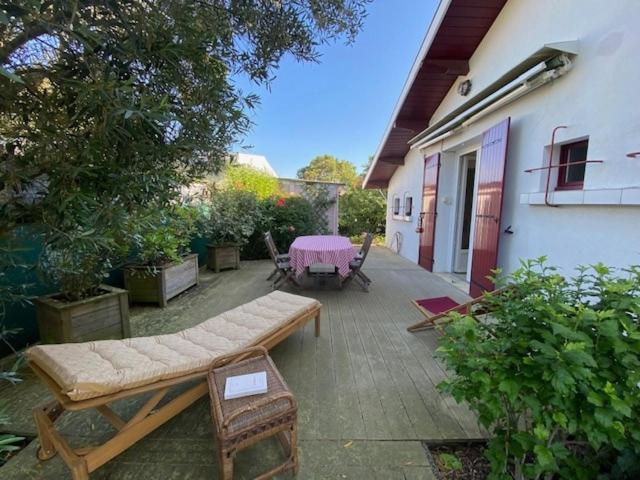 un patio avec une table et des chaises et une table et un bâtiment dans l'établissement Maison au calme à Gujan Mestras, à Gujan-Mestras