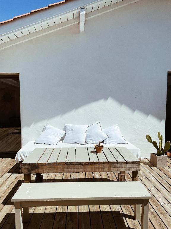 - un lit sur une terrasse en bois avec un banc dans l'établissement Maison atypique, à Anglet