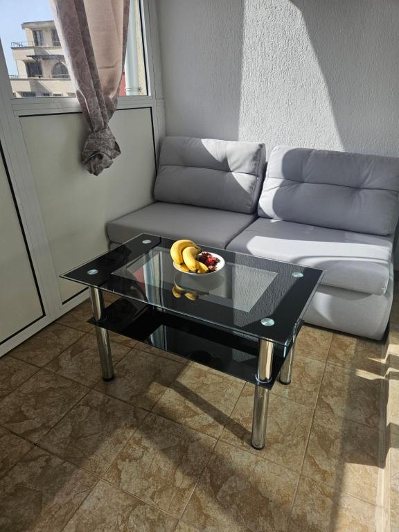 a living room with a couch and a table with a bowl of bananas at Elite 4 in Sunny Beach