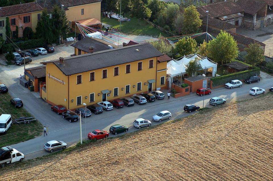una vista aérea de un edificio con coches aparcados en un aparcamiento en Albergo Escondido, en Soresina