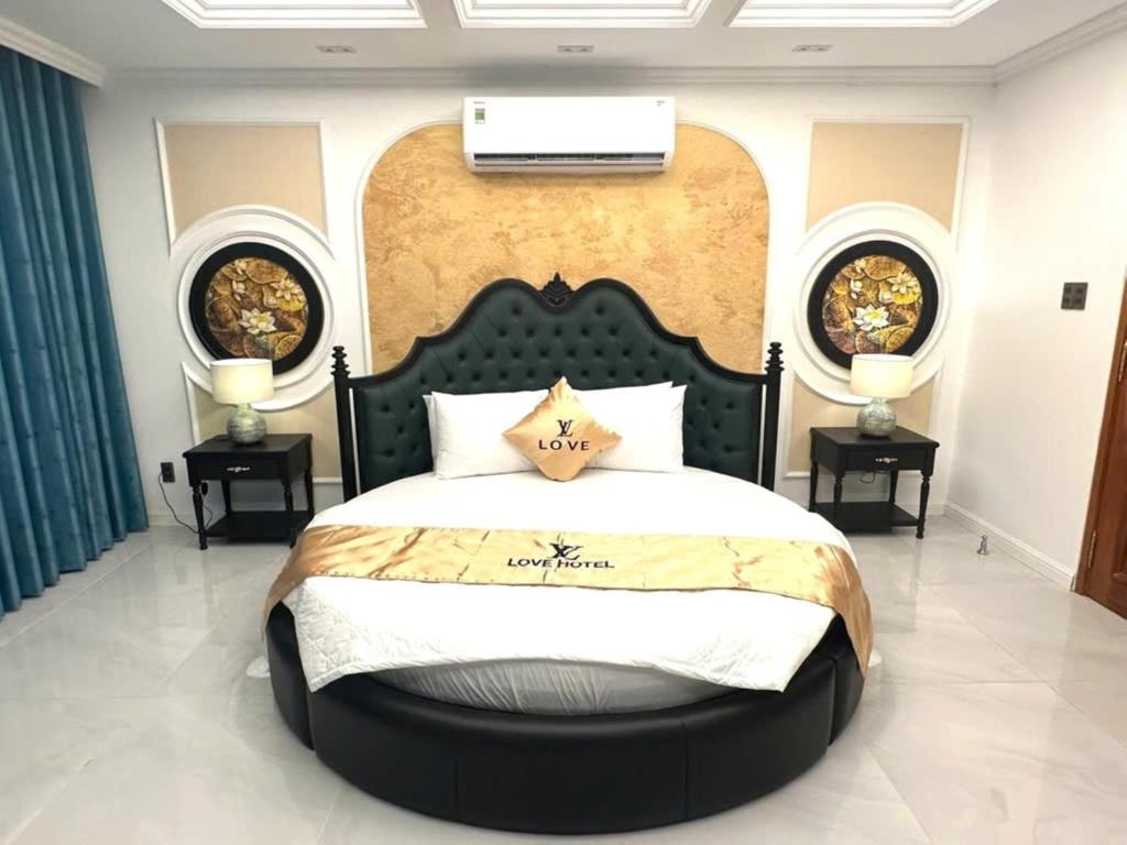 a bedroom with a large bed with two side tables at Love Luxury Hotel Bà Điểm in Ho Chi Minh City