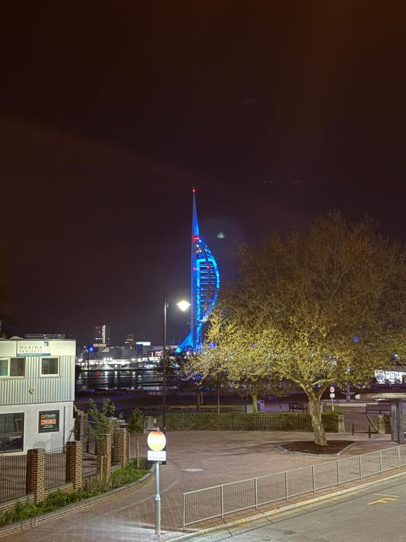 a lit up building with a blue at night at Cosy 2 bedroom modern flat close to transport link in Gosport