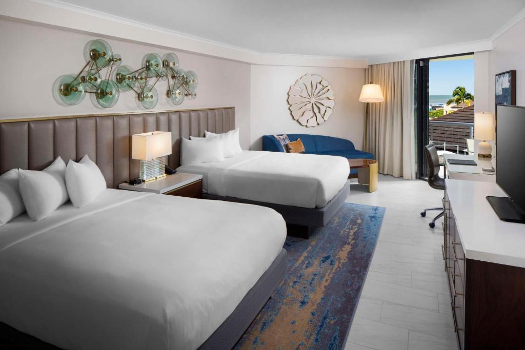 a hotel room with two beds and a balcony at Hilton Marco Island Beach Resort and Spa in Marco Island