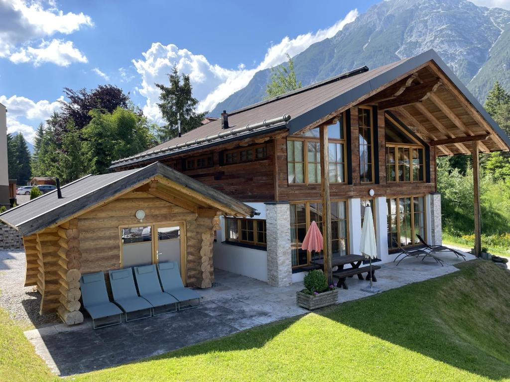 domek z krzesłami przed nim w obiekcie IM WEIDACH Superior Chalets w mieście Leutasch