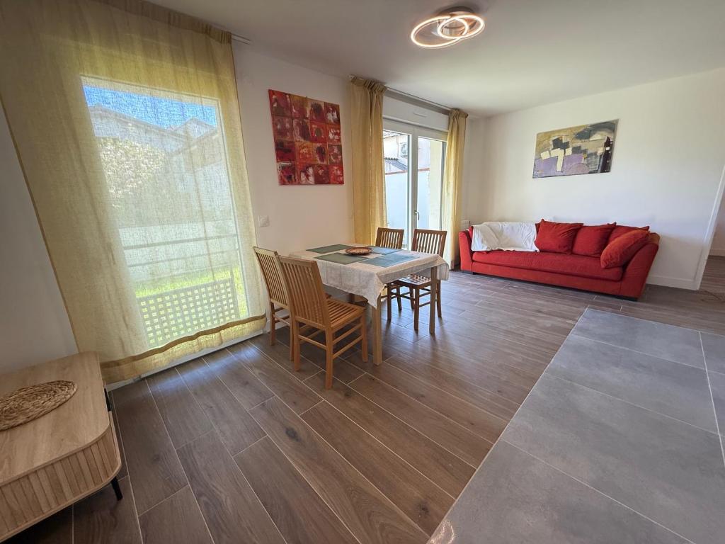 un salon avec une table et un canapé rouge dans l'établissement Villa ROSA seasonalflat Au RDC 80 rue Paul Vaillant Couturier Malakoff 92240, à Malakoff