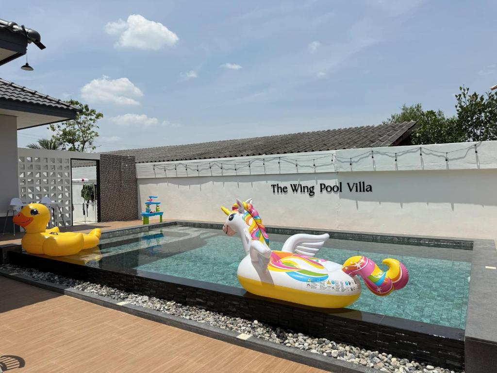a pool with two inflatable toys and a toy unicorn at The Wing Pool Villa Surin in Surin