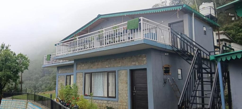 a house with a balcony on top of it at Birds Hill View Homestay in Nainital