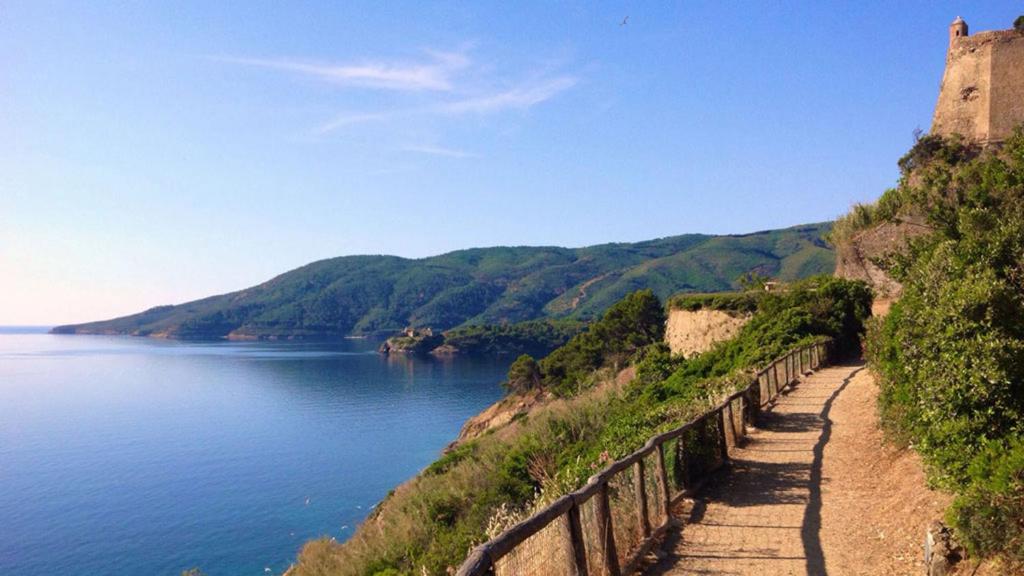 a path to a castle next to a body of water at Casa Romita 9 - ArgonautiVacanze in Porto Azzurro