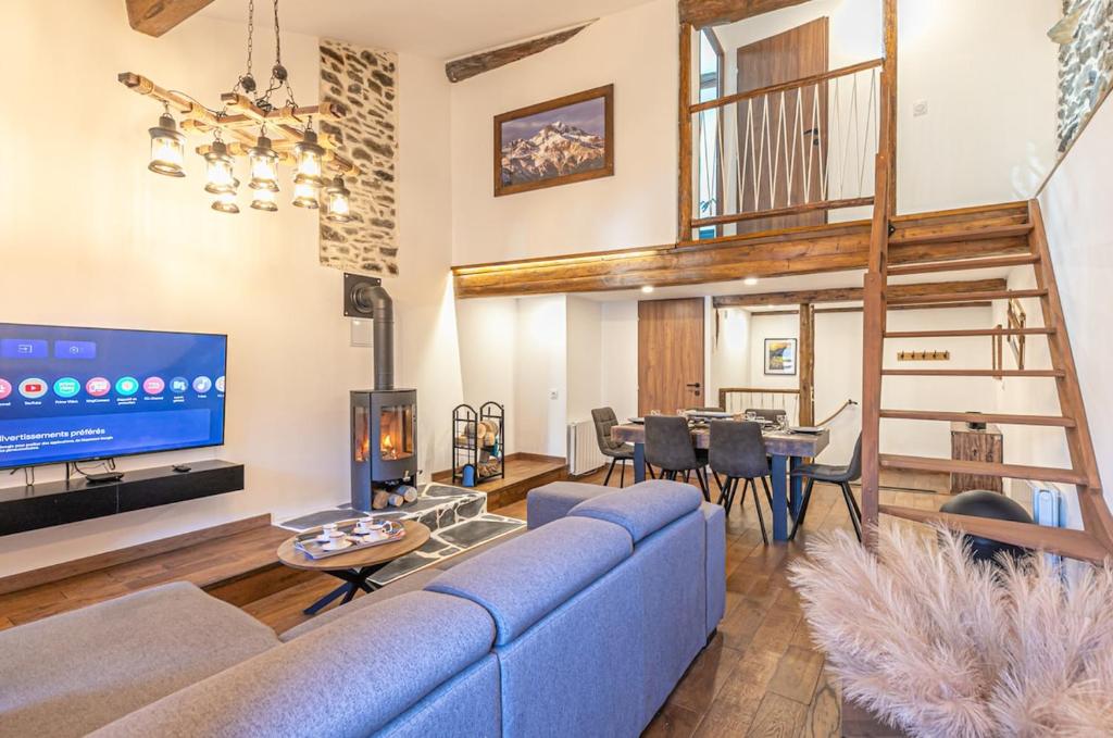 un salon avec un canapé bleu et une télévision dans l'établissement Appartement proche La norma Aussois, à Villarodin-Bourget