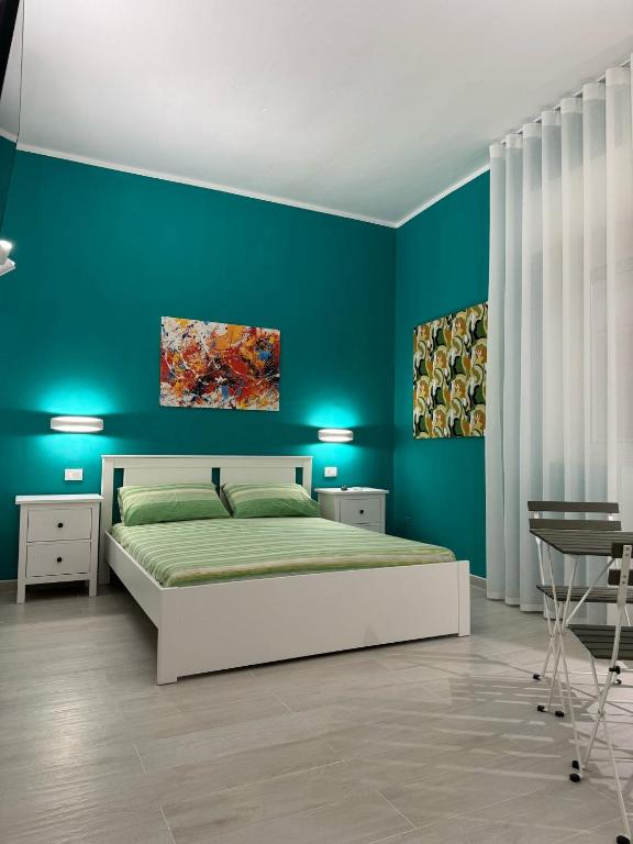 a bedroom with a bed and a blue wall at La Casa di Armando in Agrigento