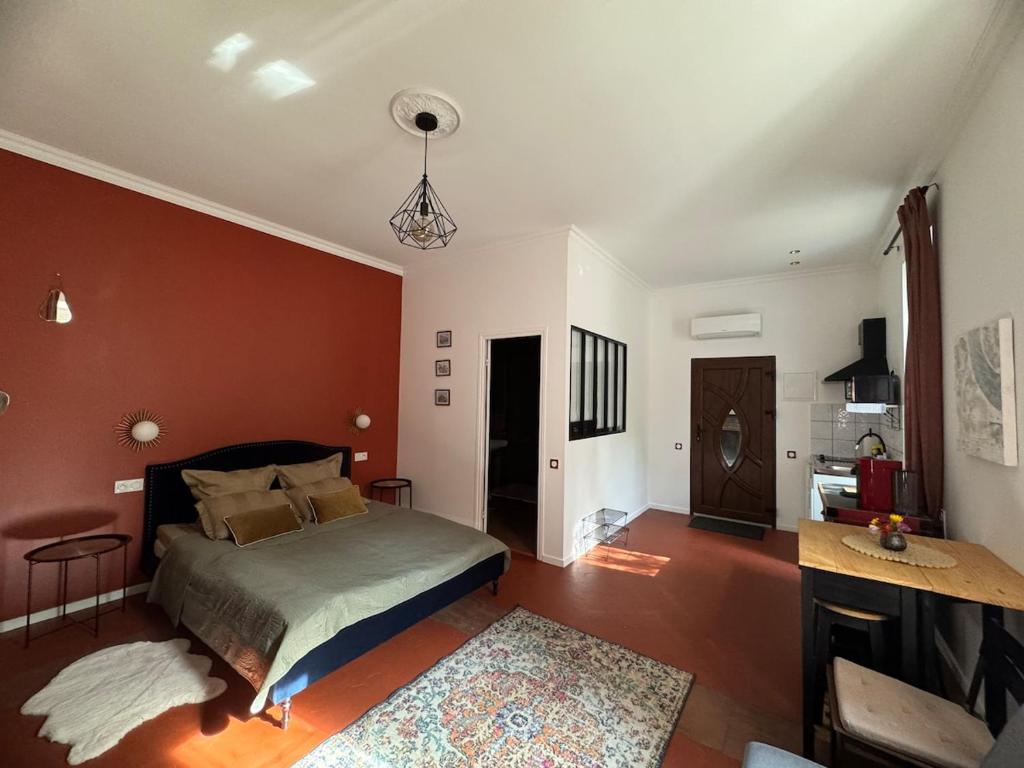 une chambre avec un lit et un mur rouge dans l'établissement Location studio vacances dans Chateau, à La Celle-sous-Gouzon