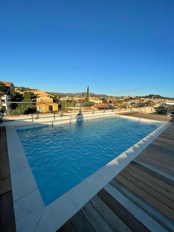 une grande piscine avec de l'eau bleue dans un immeuble dans l'établissement Appartement 2 chambres en rez de jardin avec piscine, à Cogolin